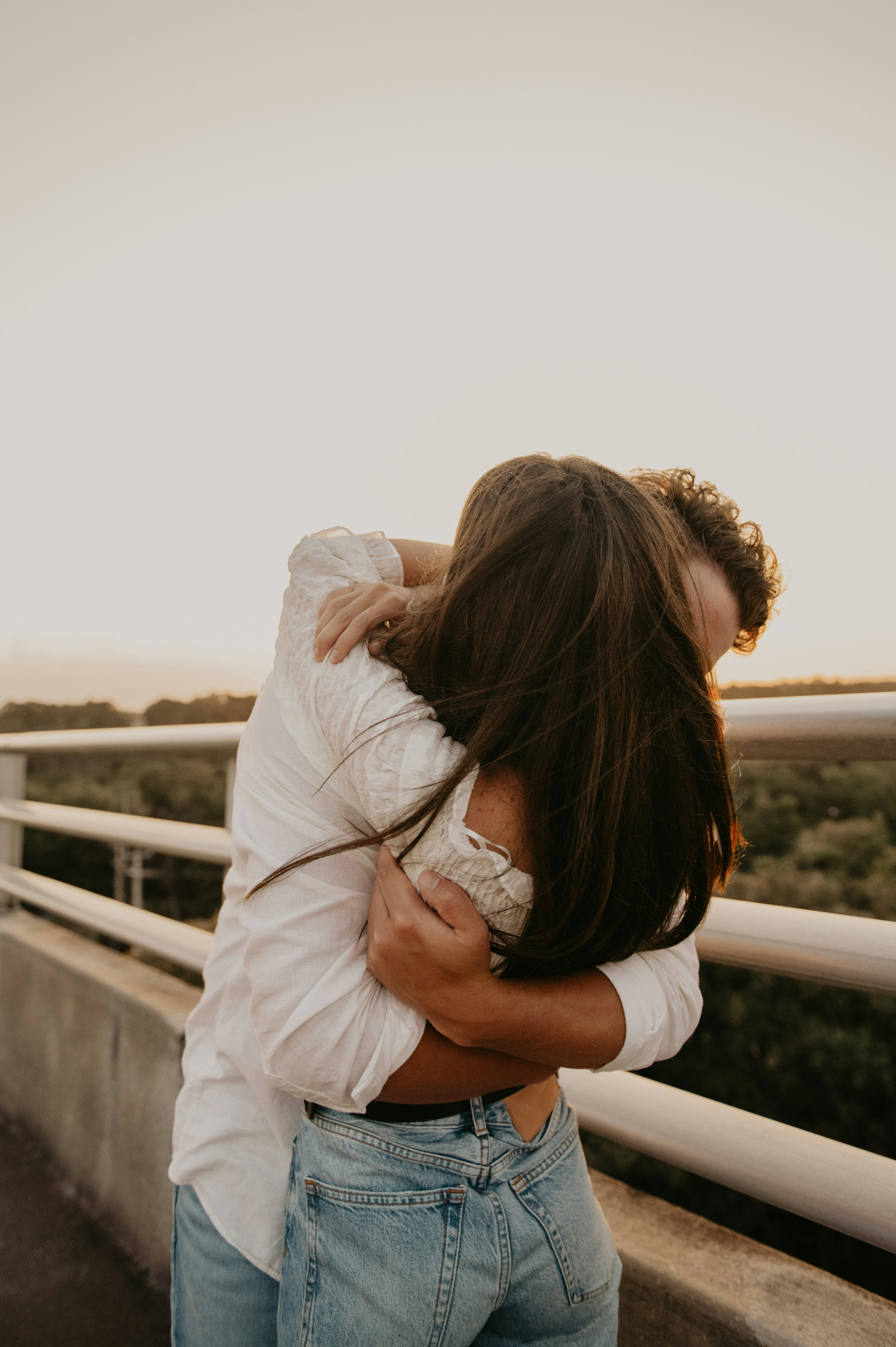 Una pareja abrazándose al atardecer — una canción personalizada para alguien que aman